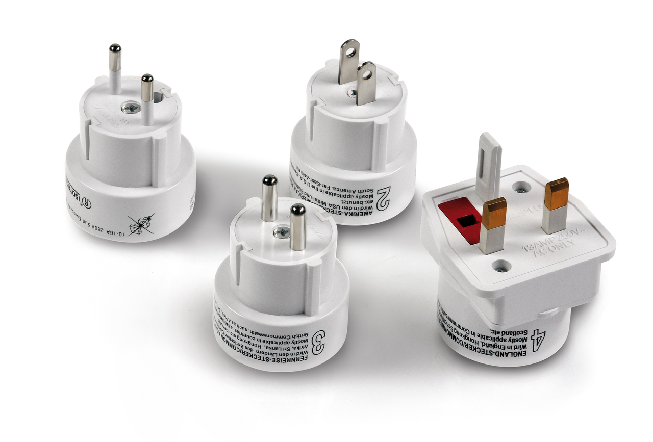 Vier Stecker auf weißem Hintergrund. Die Stecker dienen als Adapter für für andere Länder. Die abgebildeten Stecker gehören zu den Bereichen UK, USA, EU und CH.